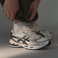 ASICS Gel Kayano 14 Cream Black Plum vastgehouden in hand met zicht op hielstructuur en retro branding, SKU 1202A056 118

