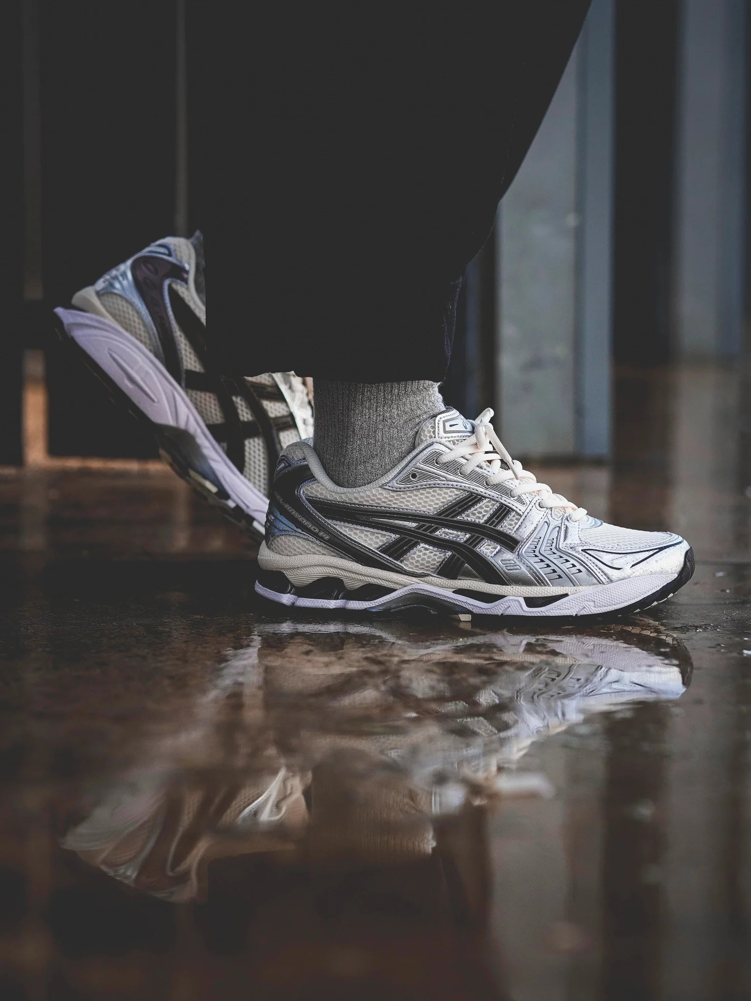 Close-up van de ASICS Gel Kayano 14 Cream Black Metallic Plum gedragen op straat – reflecterende overlays en plumkleurige accenten, model 1202A056 118

