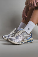 On feet shot van de ASICS Gel Kayano 14 Cream Pepper met subtiele shine en zachte demping – perfecte mix van sport en stijl

