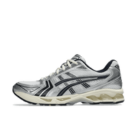 ASICS Gel-Kayano 14 JJJJound White Navy Zijaanzicht van de ASICS Gel-Kayano 14 in samenwerking met JJJJound – wit mesh met navy accenten en minimalistische branding

