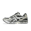 Dempende ASICS GEL-Kayano 14 in Obsidian Grey met zilveren tiger stripes en sculpted midsole, gefotografeerd vanaf laterale zijde