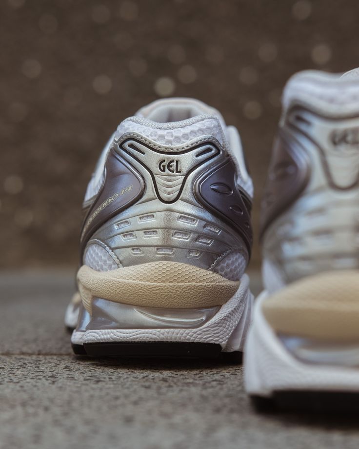 In-hand shot van Kayano 14 White Graphite Grey – lichtgewicht mesh body, zilvergrijze accenten en GEL-technologie in de zool