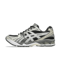 Dempende ASICS GEL-Kayano 14 in Obsidian Grey met zilveren tiger stripes en sculpted midsole, gefotografeerd vanaf laterale zijde