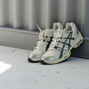 Close-up van de ASICS GEL-Nimbus 9 Cream Black 1201A424-101 met gelaagde mesh structuur, synthetische zwarte panelen en GEL-units

