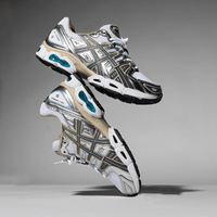 Close-up van de ASICS GEL-Nimbus 9 White Steel Grey 1201A424-102 met layered mesh structuur, silver-grey tiger stripes en GEL demping


