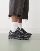 ASICS GEL-NYC Black Graphite Grey on foot gedragen in een zwarte techwear fit met moderne runner-styling via Snrkickz