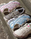 Cream Rose Water colorway van de ASICS Gel-NYC tussen andere modellen in een outdoor flatlay, ideaal voor visuele vergelijkingen tussen populaire kleuren