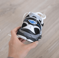 ASICS GT-2160 JJJJound Inverted Blue 1203A554-001 in hand met subtiel JJJJound-branding, ademend mesh en contrasterende donkerblauwe panelen

