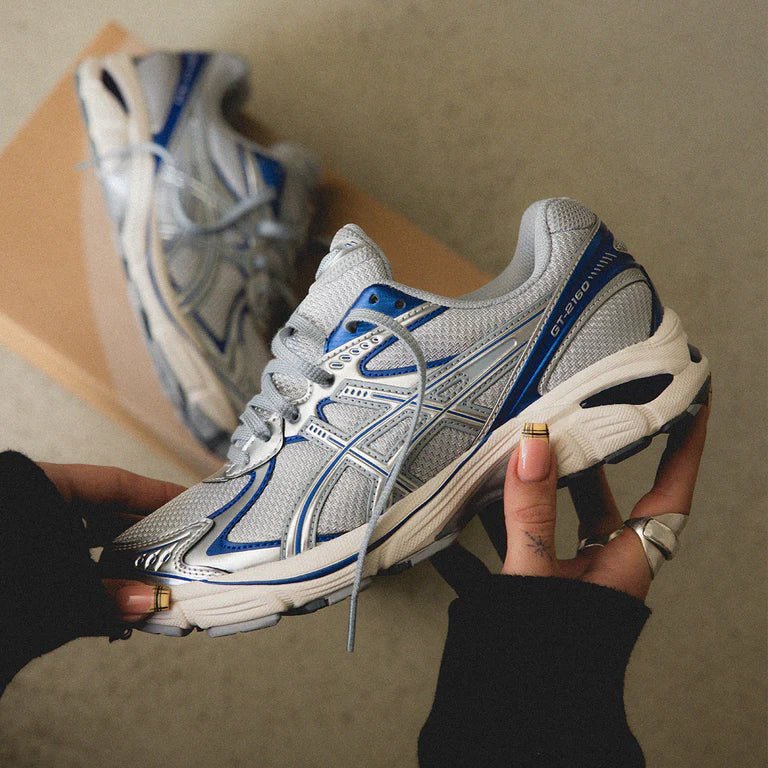 ASICS GT-2160 Piedmont Grey Deep Marine in hand met ademend mesh, stevige overlays en subtiele marineblauwe details

