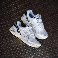 ASICS GT-2160 White Black 1203A320-100 in hand met contrasterende zwarte accenten, ademend wit mesh en reflecterende details

