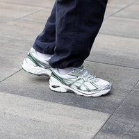 ASICS GT-2160 White Shamrock Green 1203A275-103 in hand met ademend wit mesh, felgroene panelen en reflecterende details

