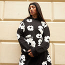 Detail van het Cotton Wreath-logo op de Denim Tears hoodie – hoogwaardige borduursels met cultureel statement in rood en wit via Snrkickz