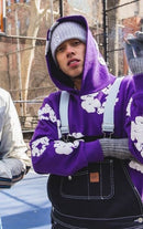 Denim Tears The Cotton Wreath Hoodie Purple – model draagt oversized fit in urban styling met baggy jeans
