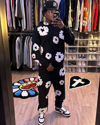 Denim Tears The Cotton Wreath Sweatpants Black – model draagt relaxed fit sweatpants in streetwear look met witte sneakers