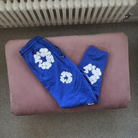 Denim Tears The Cotton Wreath Sweatpants Blue – close-up borduursel detail op zachte blauwe joggingstof