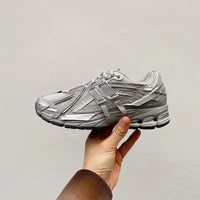 Close-up van het mesh en synthetische overlay bovenwerk van de 1906A Concrete Silver Metallic. De reflecterende metallic elementen versterken de performance look van deze sneaker.

