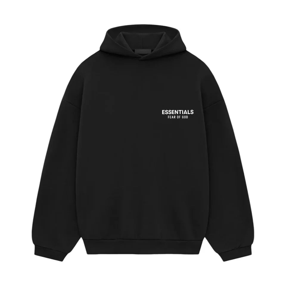 Flatlay van de zwarte Essentials FW24 hoodie met witte branding op de rug, minimalistische look in studioverlichting