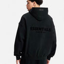 Fear of God Essentials Limo Black Hoodie on body – gedragen in een all-black streetwear fit, relaxed oversized look via Snrkickz