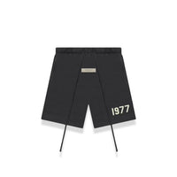 Fear of God Essentials 1977 Iron shorts flat lay featuring minimal 1977 logo, elastic waistband and tonal drawcords.