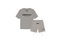 Fear of God Essentials Dark Oatmeal Summer Set with T-shirt and shorts displayed flat on neutral beige background.