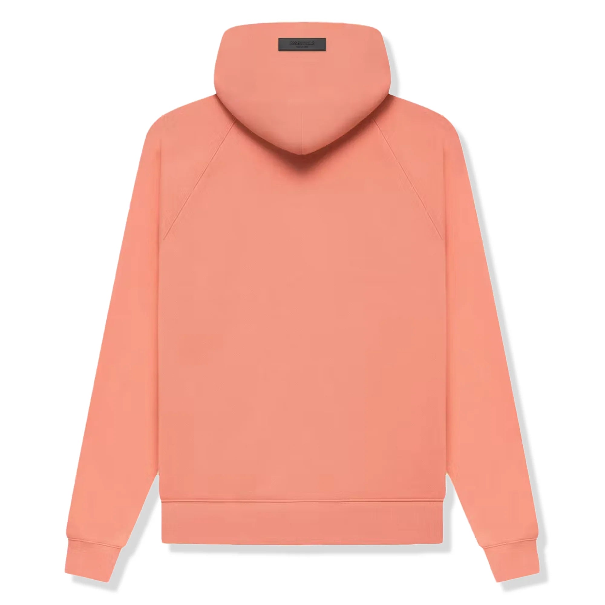 Model wearing Fear of God Essentials FW22 Coral Hoodie highlighting oversized fit, bright coral color and relaxed premium streetwear style.