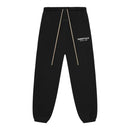 Fear of God Essentials FW24 Black White sweatpants displayed flat highlighting elastic cuffs and tonal logo design.