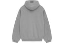 Model wearing Fear of God Essentials FW24 Dark Heather Hoodie highlighting oversized fit, cozy cotton fabric and minimalist streetwear style.