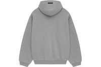 Model wearing Fear of God Essentials FW24 Dark Heather Hoodie highlighting oversized fit, cozy cotton fabric and minimalist streetwear style.