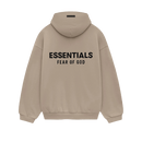 Model wearing Fear of God Essentials FW24 Desert Sand Hoodie styled with neutral pants highlighting oversized fit, cozy fabric and clean streetwear look.