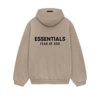 Model wearing Fear of God Essentials FW24 Desert Sand Hoodie styled with neutral pants highlighting oversized fit, cozy fabric and clean streetwear look.