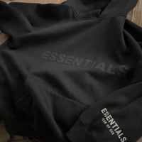 Fear of God Essentials Hoodie Black – close-up detail van zachte zwarte stof en borduursel