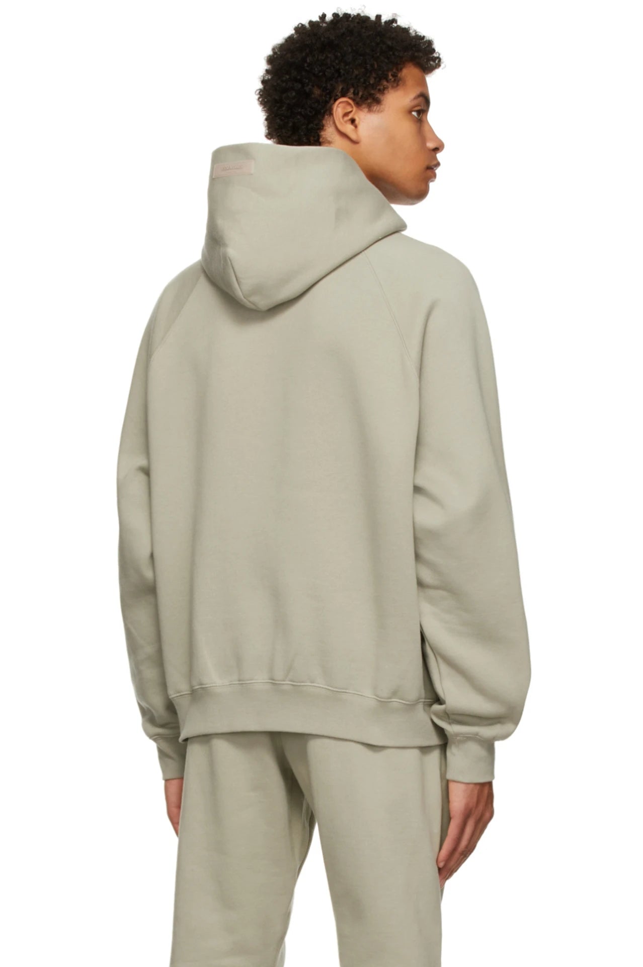 Fear of God Essentials Seafoam Hoodie – achterkant model in oversized lichtgroene hoodie met capuchon en relaxte styling
