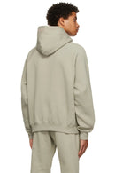 Fear of God Essentials Seafoam Hoodie – achterkant model in oversized lichtgroene hoodie met capuchon en relaxte styling