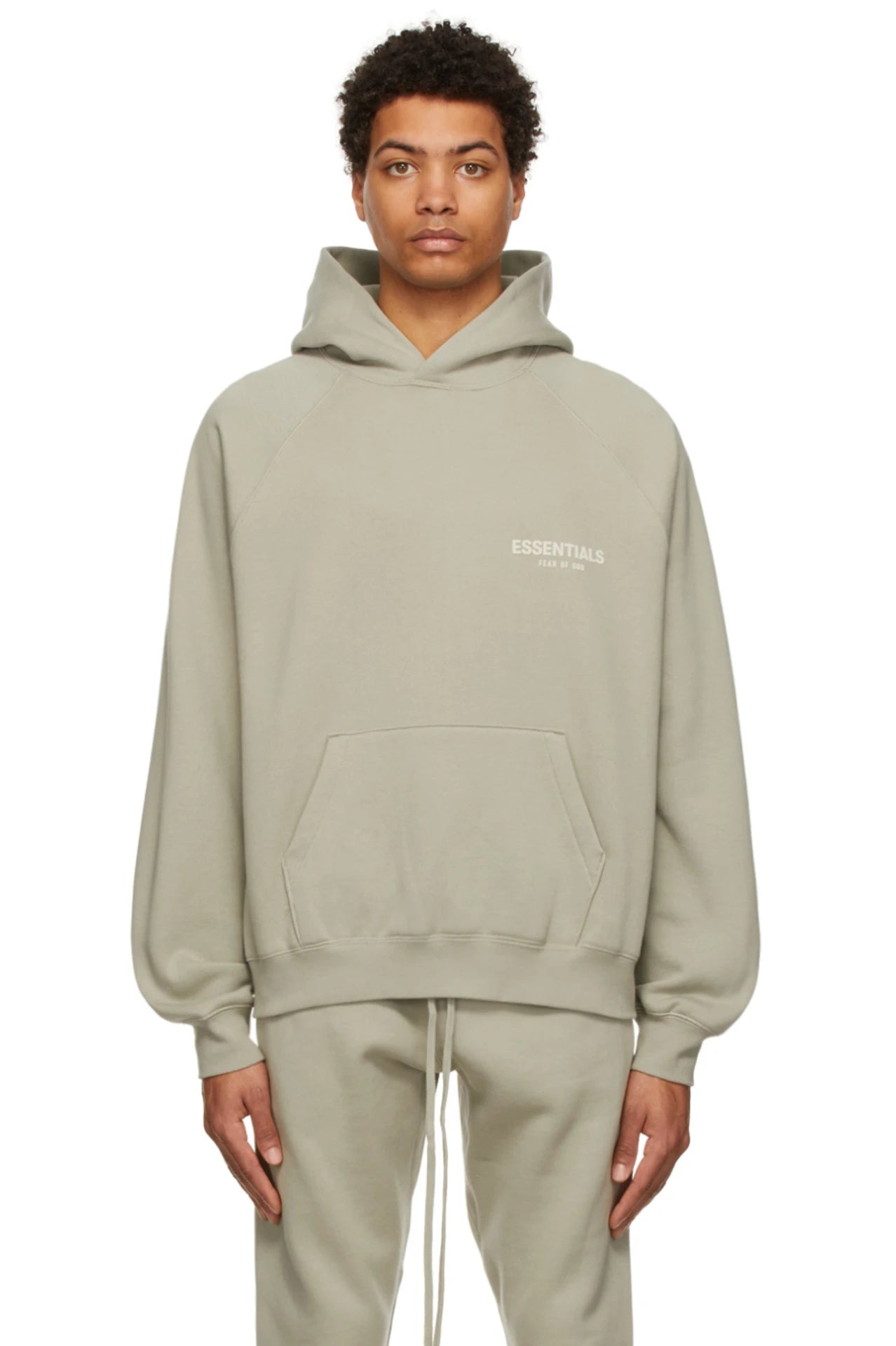 Fear of God Essentials Sage Hoodie – zijaanzicht model in oversized lichtgroene hoodie met lange mouwen en capuchon