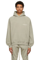 Fear of God Essentials Sage Hoodie – zijaanzicht model in oversized lichtgroene hoodie met lange mouwen en capuchon