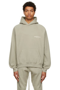 Fear of God Essentials Sage Hoodie – zijaanzicht model in oversized lichtgroene hoodie met lange mouwen en capuchon