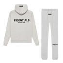 Fear of God Essentials Light Oatmeal Full Set met hoodie en sweatpants in lichte beige Oatmeal tint, premium katoen streetwear outfit met zwart Essentials-logo op rug en dij