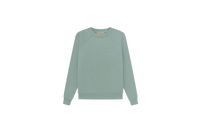 Fear of God Essentials Sycamore Sweater flat lay showing muted green tone, soft knit texture and minimalist Essentials chest logo.