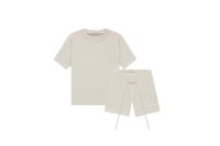 Fear of God Essentials Wheat Summer Set with short sleeve T-shirt and shorts displayed flat on neutral beige background.