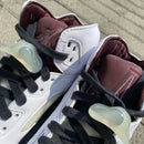 Detail van Jordan 5 A Ma Maniére Burgundy Crush (SKU IB1528‑100) met metallic silver eyelets en reflecterende tongue