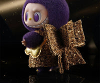 LABUBU × PRONOUNCE Wings of Fortune – close‑up op kunstzinnige vinyl‑plush mix, metallic gouden vleugels en zachte pastel textuur