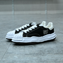 Maison Mihara Yasuhiro Blakey OG Sole Canvas Low Black - Maison Mihara Yasuhiro Blakey OG Sole Canvas Low Black – model draagt Regular fit sneaker met tapered denim voor een avant-garde streetwear look