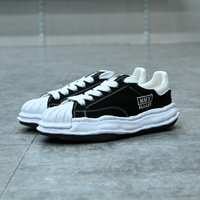 Maison Mihara Yasuhiro Blakey OG Sole Canvas Low Black - Maison Mihara Yasuhiro Blakey OG Sole Canvas Low Black – model draagt Regular fit sneaker met tapered denim voor een avant-garde streetwear look