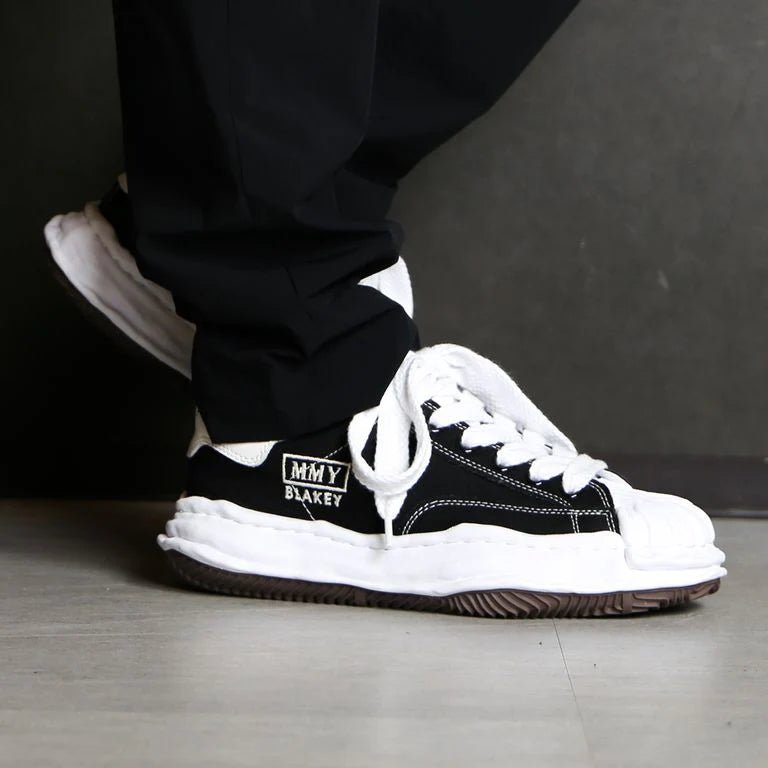 Maison Mihara Yasuhiro Blakey OG Sole Canvas Low Black – detail van tonglabel en hielbadge met SKU A08FW735 en subtiele MMY-branding