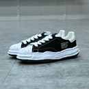 Maison Mihara Yasuhiro Blakey OG Sole Canvas Low Black - Maison Mihara Yasuhiro Blakey OG Sole Canvas Low Black – model draagt Regular fit sneaker met tapered denim voor een avant-garde streetwear look