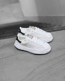 Maison Mihara Yasuhiro Blakey OG Sole Leather Low White (SKU A06FW702-WHT) – model draagt deze Regular fit sneaker met tapered denim voor een avant-garde streetwear look