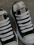 A01FW705 BLK MHY-HANK-OG-BLK Maison Mihara Yasuhiro Hank OG Sole Canvas Low Black – detail hielbadge en tonglabel met A01FW705 BLK SKU en subtiele merkemblemen