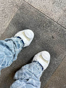 MHY-HANK-OG-WHT Maison Mihara Yasuhiro Hank OG Sole Canvas Low White – model draagt Regular fit met tapered jeans voor een avant-garde streetwear look