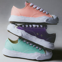 MHY-HANK-OG-PUR Maison Mihara Yasuhiro Hank OG Sole Canvas Low Purple – model draagt Regular fit met tapered denim voor een avant-garde streetwear look