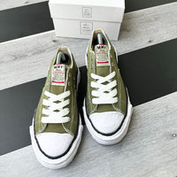 Maison Mihara Yasuhiro Peterson 23 OG Sole Canvas Low Green – model draagt Regular fit sneaker met tapered denim voor een minimalistische streetwear look